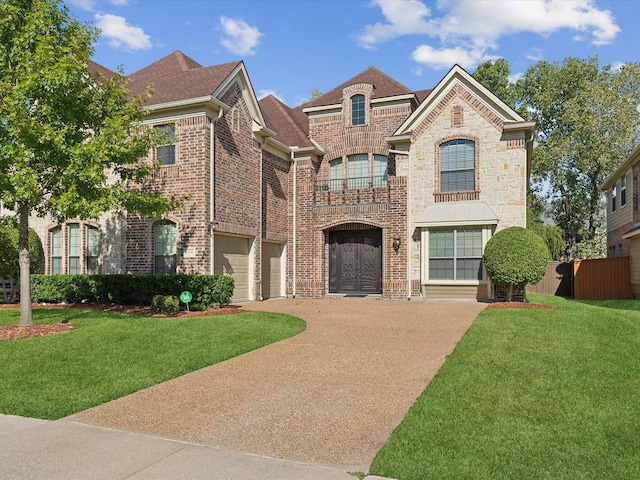 view of front of house featuring a garage, a front lawn, and a balcony