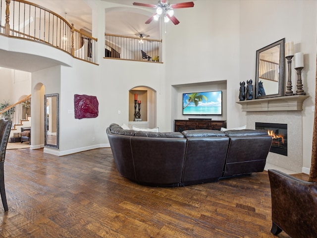 living room featuring ceiling fan, dark hardwood / wood-style flooring, and a high ceiling