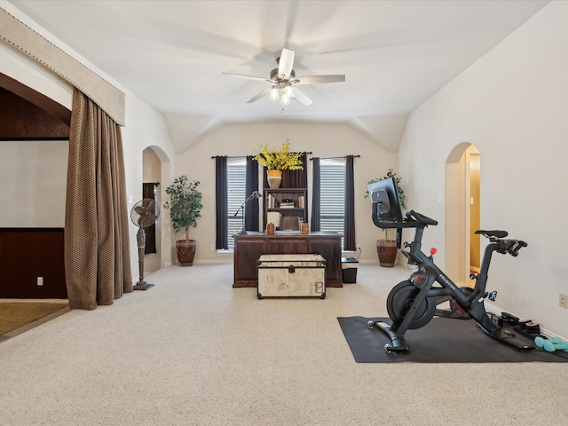 exercise area with lofted ceiling, light colored carpet, and ceiling fan