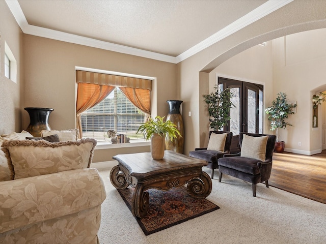 carpeted living room featuring crown molding, a textured ceiling, and french doors