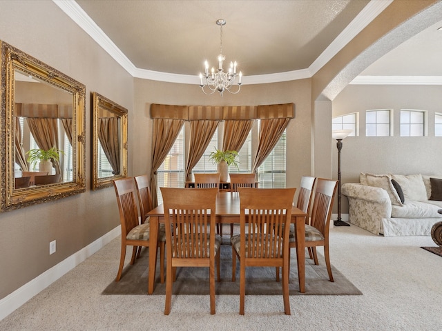 carpeted dining space featuring ornamental molding and a chandelier