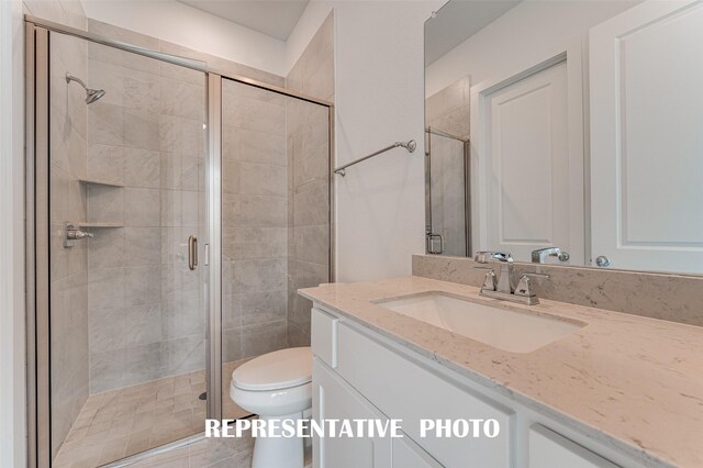 bathroom featuring walk in shower, vanity, and toilet