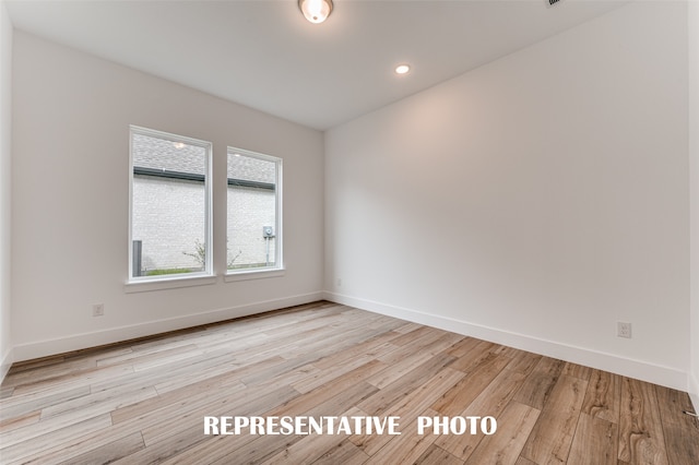 unfurnished room with light wood-type flooring