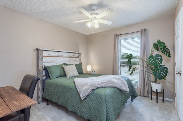 bedroom featuring a textured ceiling, light carpet, and ceiling fan