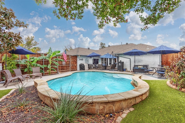 view of pool with outdoor lounge area, a patio, and a yard