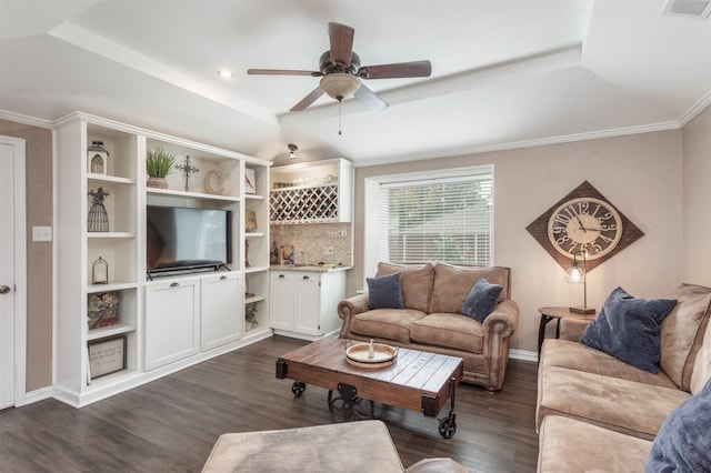 living room featuring ornamental molding, dark wood-type flooring, ceiling fan, and a tray ceiling