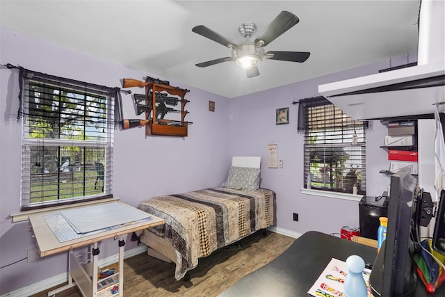 bedroom featuring hardwood / wood-style floors, ceiling fan, and multiple windows