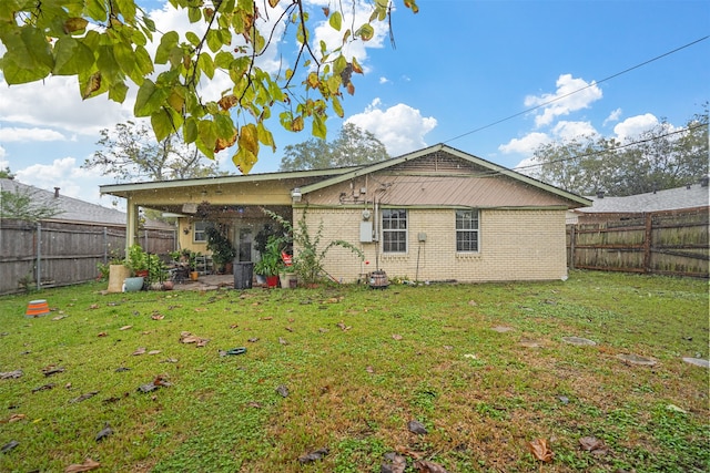 back of house with a patio and a yard