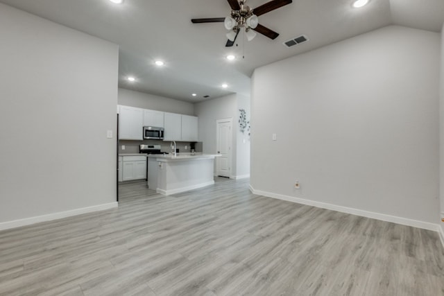 kitchen featuring a center island with sink, appliances with stainless steel finishes, ceiling fan, light hardwood / wood-style flooring, and white cabinets