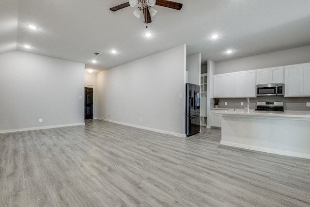 kitchen featuring white cabinets, stainless steel appliances, light hardwood / wood-style floors, and ceiling fan