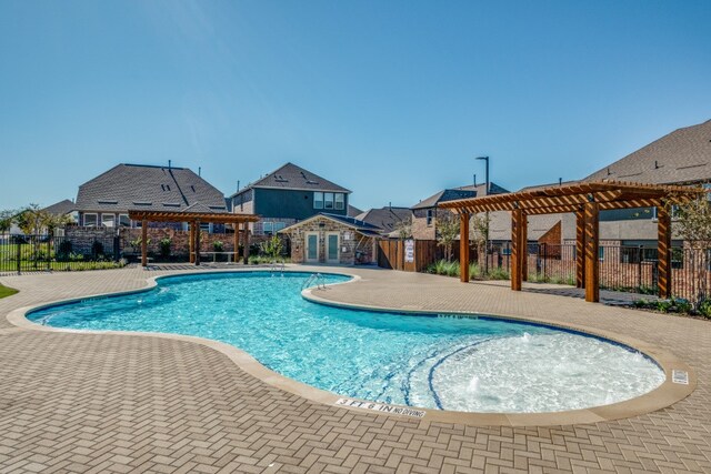 view of swimming pool with a patio, a pergola, and pool water feature