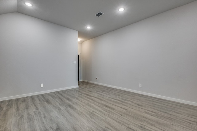 empty room featuring light hardwood / wood-style flooring and lofted ceiling