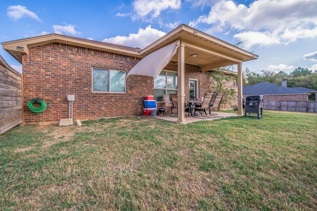 back of property featuring a lawn and a patio area