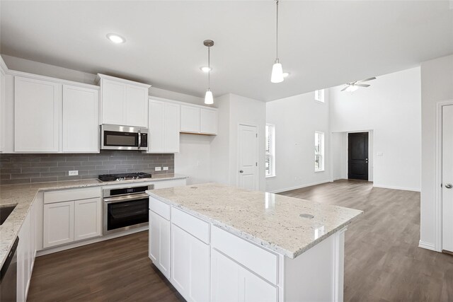 kitchen with white cabinets, light hardwood / wood-style flooring, ceiling fan, a kitchen island, and stainless steel appliances