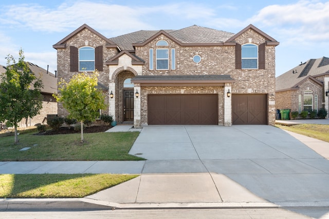 view of front of property featuring a front yard and a garage