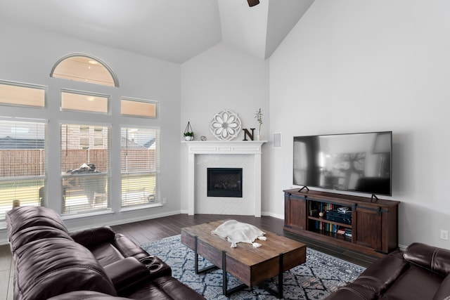 living room with dark hardwood / wood-style floors, ceiling fan, and high vaulted ceiling