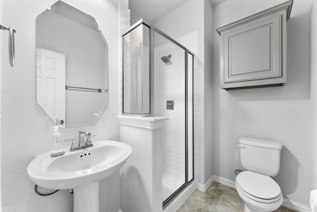 bathroom with tile patterned floors, toilet, a shower with door, and sink