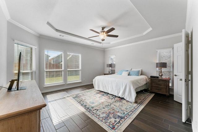 bedroom featuring ornamental molding, dark hardwood / wood-style floors, ceiling fan, and a tray ceiling