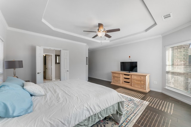 bedroom featuring dark hardwood / wood-style flooring, a tray ceiling, ceiling fan, and crown molding