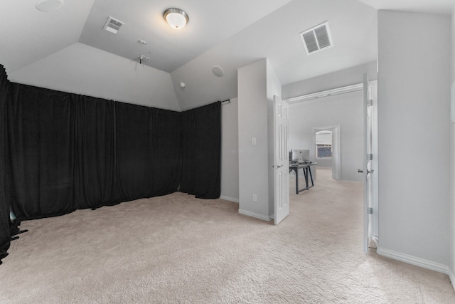 interior space featuring lofted ceiling and light carpet