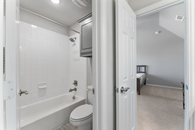 bathroom with tiled shower / bath combo and toilet