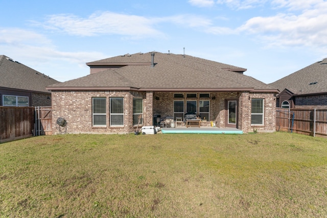 rear view of house featuring a lawn and a patio