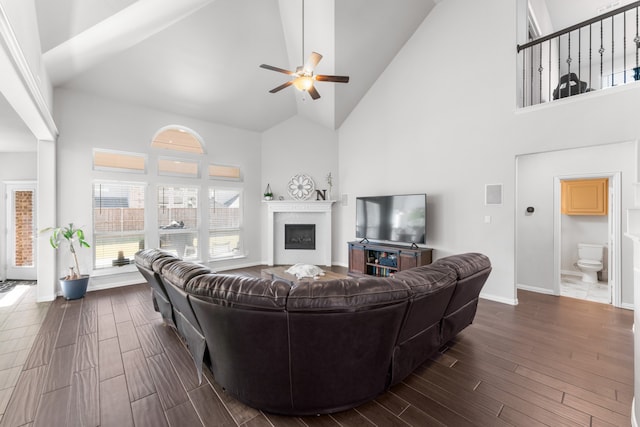 living room with dark hardwood / wood-style floors, ceiling fan, and high vaulted ceiling