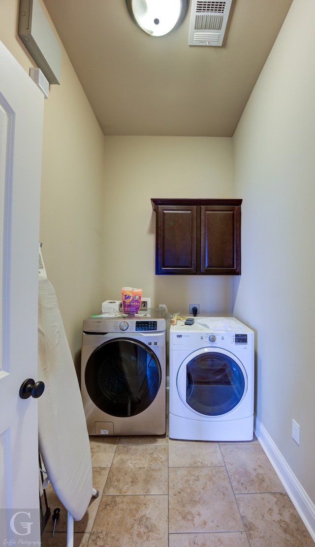 washroom featuring cabinets, washer and dryer, and light tile patterned floors