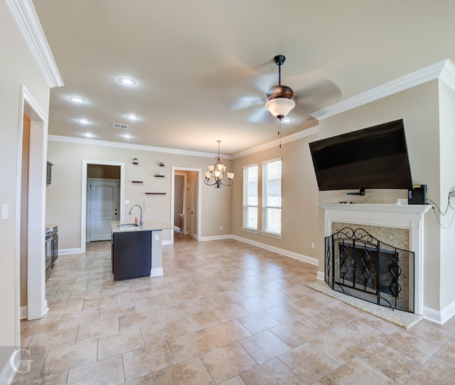 unfurnished living room featuring sink, ornamental molding, and ceiling fan with notable chandelier