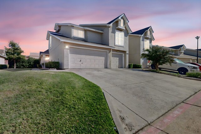 view of front property featuring a garage and a yard