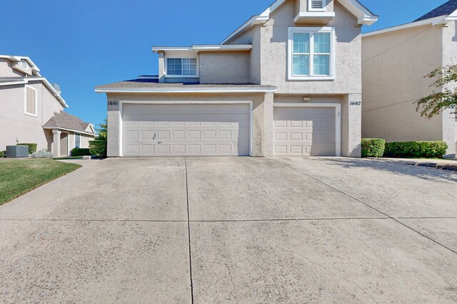 view of front property featuring central air condition unit and a garage