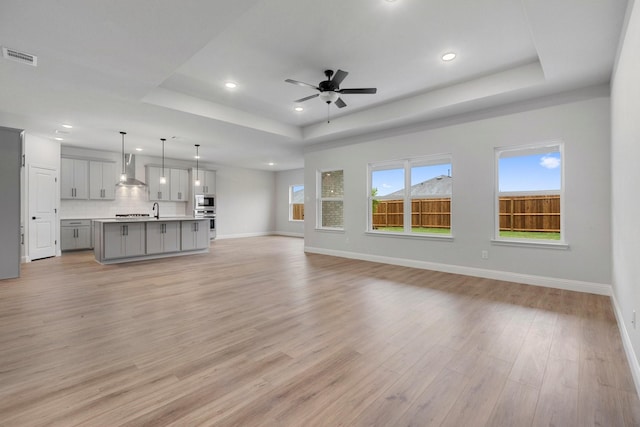 219 Briarwood Dr, Nevada, TX 75173 - unfurnished living room with a raised ceiling, recessed lighting, light wood finished floors, and ceiling fan