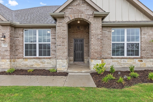 219 Briarwood Dr, Nevada, TX 75173 - doorway to property featuring board and batten siding, roof with shingles, brick siding, and stone siding