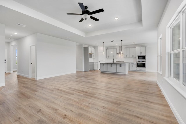 219 Briarwood Dr, Nevada, TX 75173 - unfurnished living room featuring light wood finished floors, recessed lighting, ceiling fan, and a raised ceiling