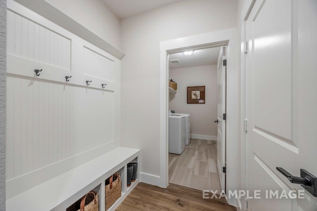 mudroom with hardwood / wood-style flooring and washing machine and clothes dryer