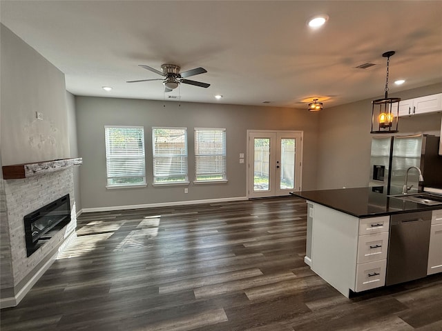 kitchen with white cabinetry, plenty of natural light, stainless steel dishwasher, and decorative light fixtures