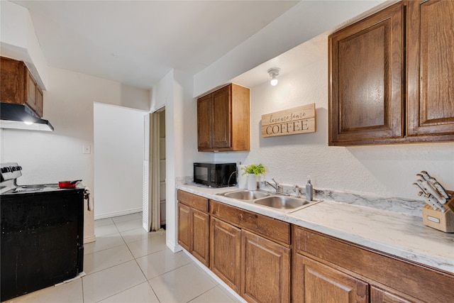 kitchen with stove, sink, and light tile patterned floors