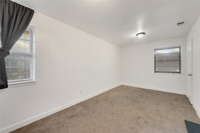 carpeted empty room with plenty of natural light