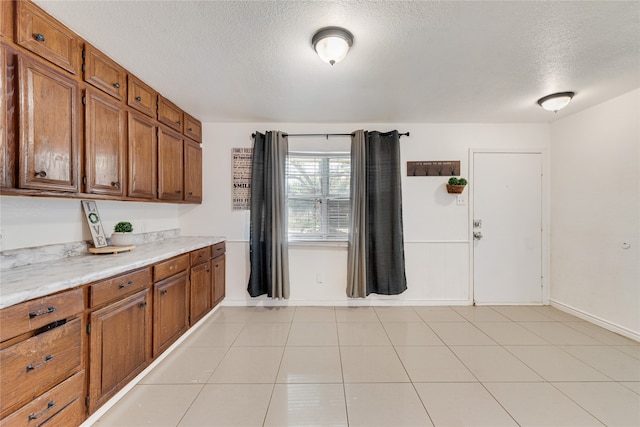 kitchen with a textured ceiling and light tile patterned floors