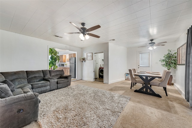 living room with light carpet, ceiling fan, and washer / clothes dryer