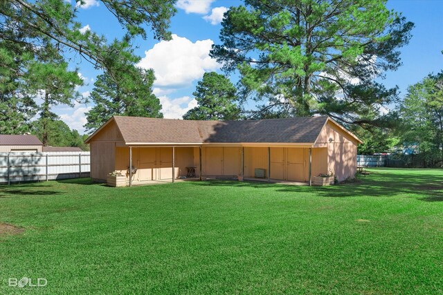 rear view of house with an outbuilding and a lawn