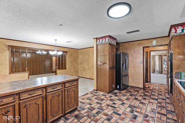 kitchen featuring stainless steel fridge, crown molding, decorative light fixtures, a textured ceiling, and an inviting chandelier