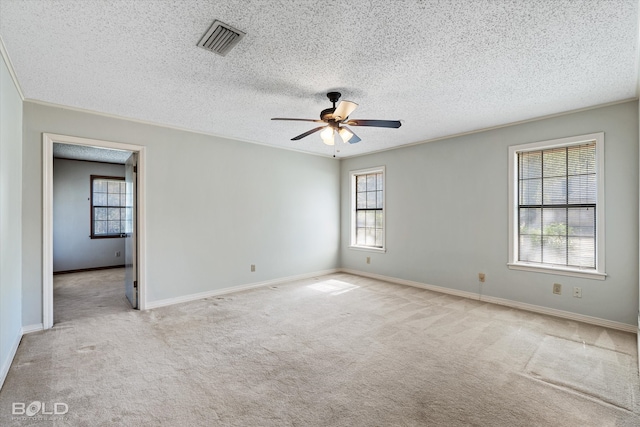 spare room featuring light carpet, ceiling fan, and plenty of natural light