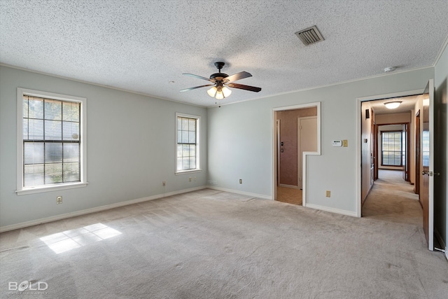 unfurnished bedroom featuring a textured ceiling, light carpet, and ceiling fan