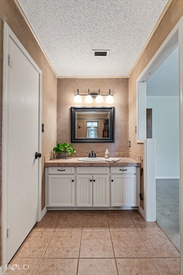 bathroom featuring tile patterned flooring, vanity, and a textured ceiling