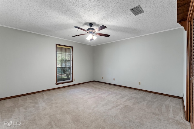 carpeted spare room with ceiling fan, a textured ceiling, and ornamental molding