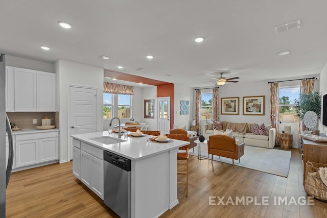 kitchen with dishwasher, visible vents, white cabinets, and a sink