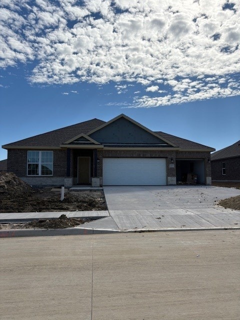 ranch-style home with a garage, driveway, and brick siding