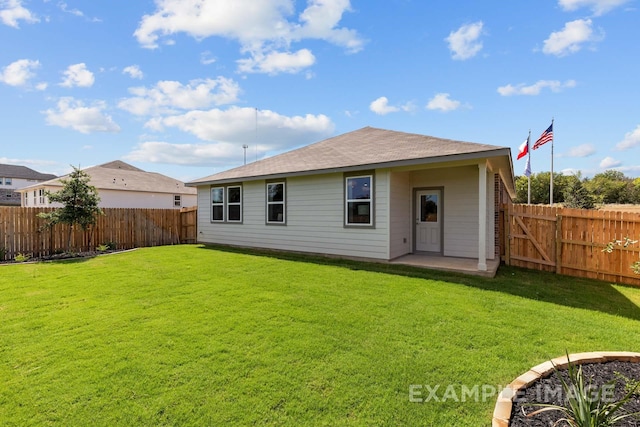 rear view of property with a fenced backyard and a lawn