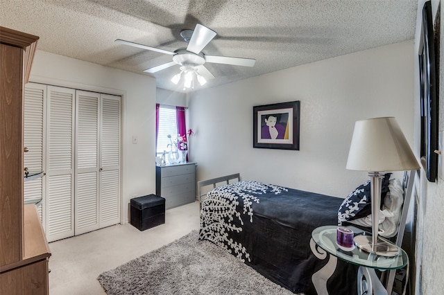 bedroom with ceiling fan, a closet, carpet flooring, and a textured ceiling